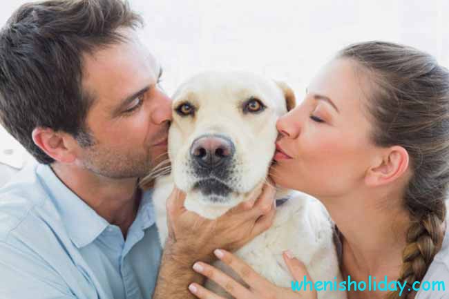 Man and woman kissing dog